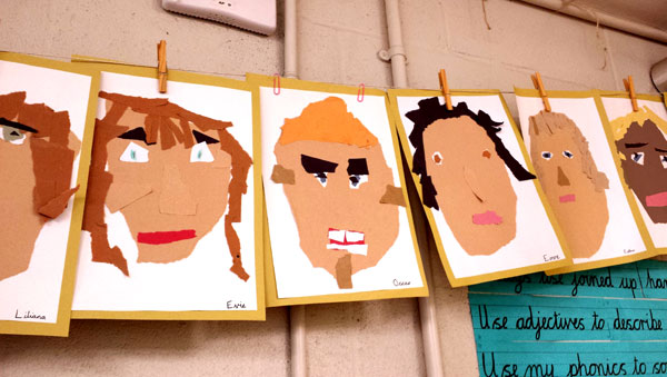 children's self portraits hanging in a classroom