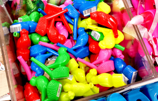 a pile of colourful bird whistle toys