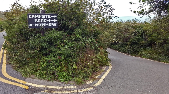 Handwritten sign points one way to campsite and beach, and the other to 'nowhere'!